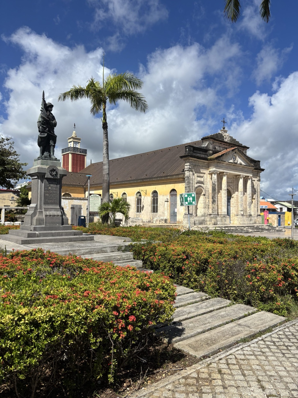 Bâtiment patrimonial, monument et cheminements dans un espace public en Guadeloupe